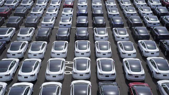 A photo of a parking lot full of Tesla cars. 